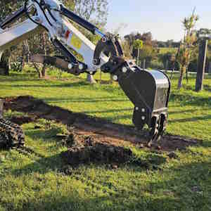 Mini excavator trenching on site