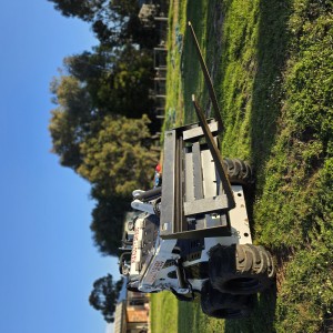 Mini excavator with auger attachment